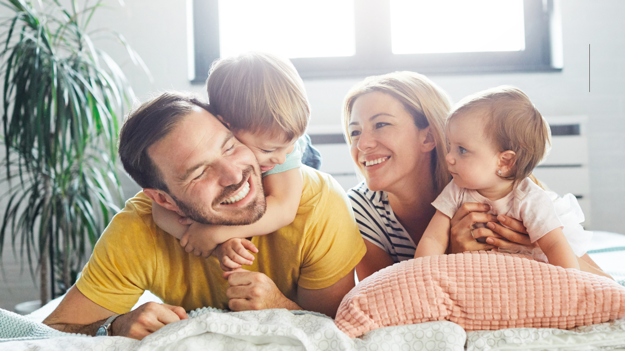 Family laughing on the bed in the refinanced home